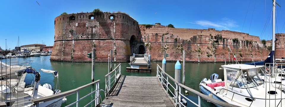 Livorno, Tuscany, Italy - 06.27.2026: view of Historic Old fortress with a moat and docked sailboats, showcasing Livorno's maritime heritage and architecture