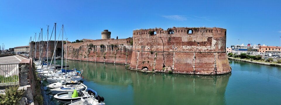 Livorno, Tuscany, Italy - 06.27.2026: view of Historic Old fortress with a moat and docked sailboats, showcasing Livorno's maritime heritage and architecture