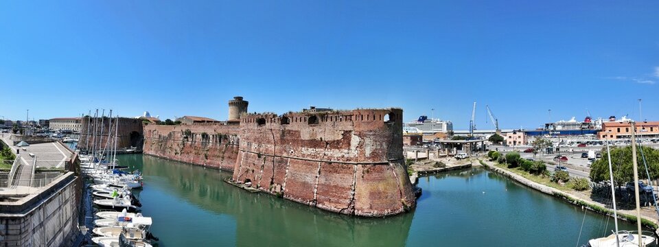 Livorno, Tuscany, Italy - 06.27.2026: view of Historic Old fortress with a moat and docked sailboats, showcasing Livorno's maritime heritage and architecture