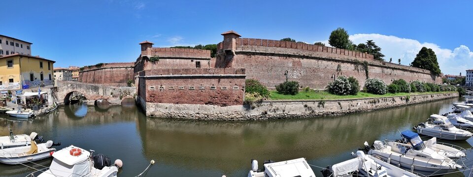 Livorno, Tuscany, Italy - 06.27.2026: view of Historic Old fortress with a moat and docked sailboats, showcasing Livorno's maritime heritage and architecture