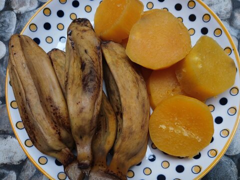 ​Boiled bananas and sliced sweet potatoes served on a ceramic plate, traditional Indonesian healthy snack.