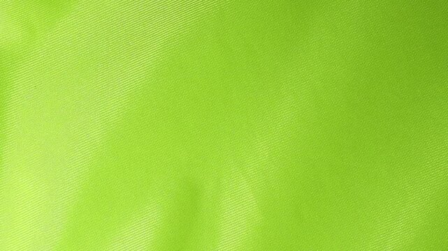 Vivid bright green fabric featuring a fine diagonal weave pattern, showcasing the detailed texture and rich color saturation of the material.