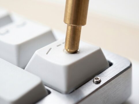 Brass soldering iron tip touching mechanical keyboard keycap electronics repair