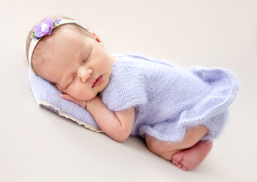 Baby Girl In A Purple Dress Sleeping During Newborn Photoshoot