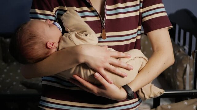 Mother gently cradling her sleeping newborn baby