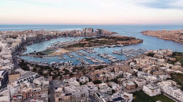Aerial view of the Msida Marina filled with yachts and surrounded by urban architecture during a clear day in Ta' Xbiex, Eastern Region, Malta.