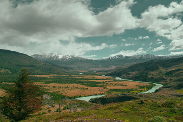 Naklejka premium Golden Patagonian Valley with Winding River and Snow-Capped Andes on the Trail to Dickson, Torres del Paine