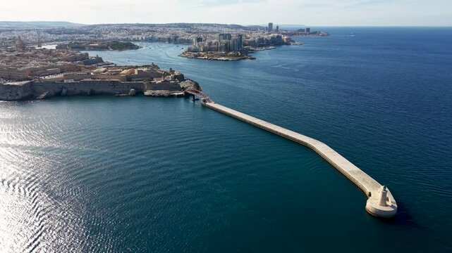 Aerial view of Saint Elmo lighthouse at the end of the breakwater with Fort Saint Elmo and the Mediterranean Sea in Valletta, Port Region, Malta.