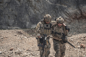 Obraz premium Soldiers assisting an injured teammate during a military field operation, demonstrating teamwork, rescue support, tactical coordination, leadership, endurance, and mission readiness in a challenging 