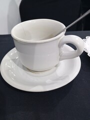 Obraz premium Empty Dirty White Ceramic Coffee Cup with Saucer and Spoon After Drinking