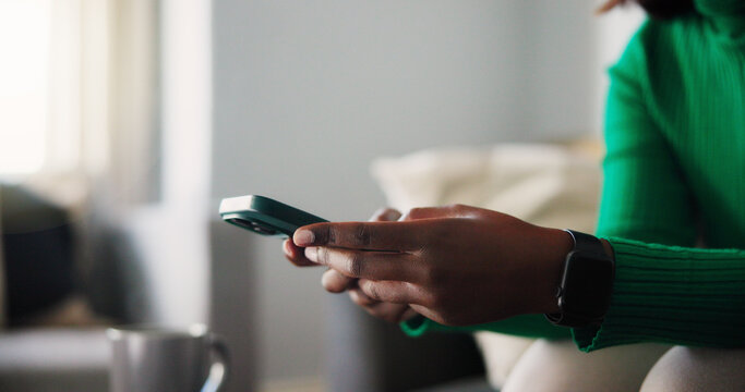 Casual Home Workspace: Person Using Smartphone and Smartwatch on Sofa Stock Photo