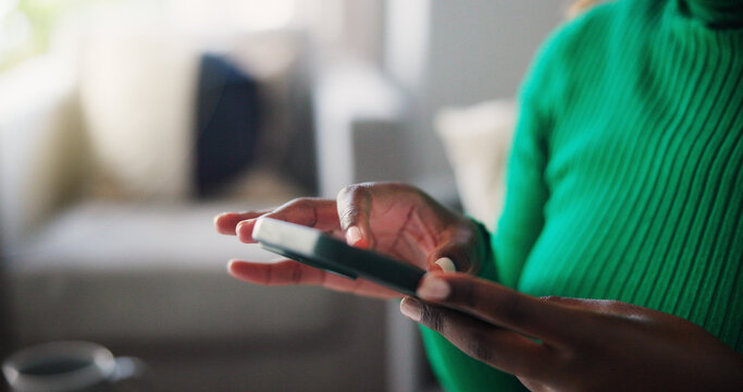 Close-Up of Woman Using Smartphone While Sitting in Living Room Wearing Green Sweater Stock Photo
