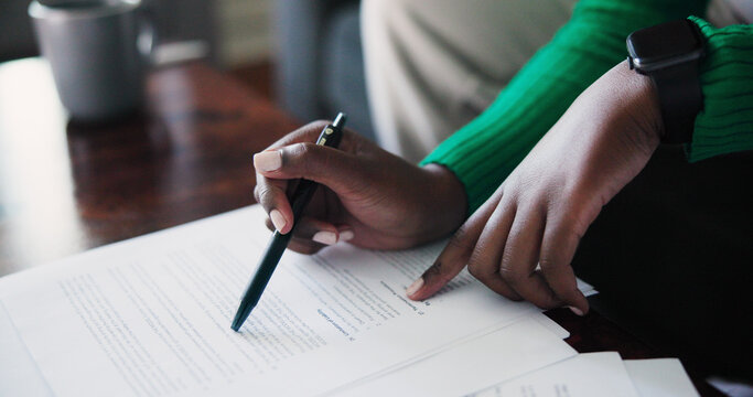 Close-Up Of Hands Reviewing Documents With Pen And Smartwatch During Remote Work Session Stock Photo