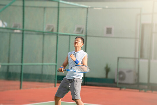 A boy is on the tennis court to play tennis.