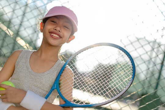 A girl is on the tennis court to play tennis.