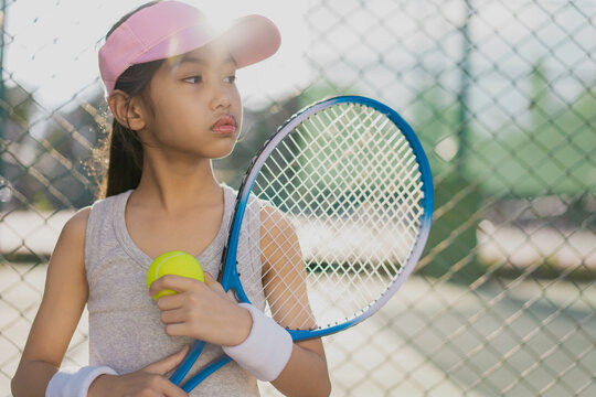 A girl is on the tennis court to play tennis.