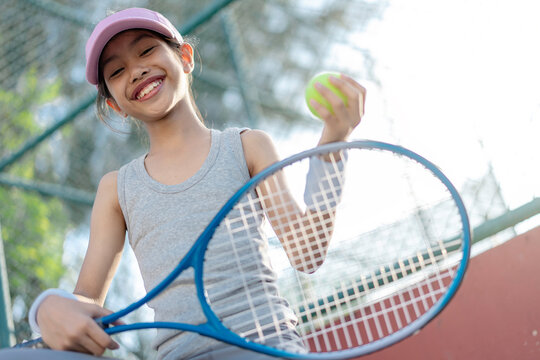 A girl is on the tennis court to play tennis.