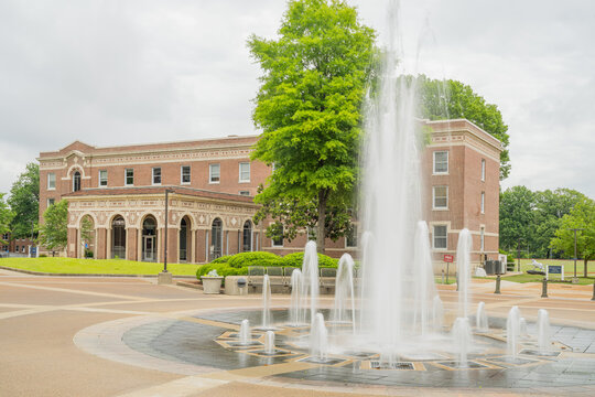 Water fountain in front of historic brick university building