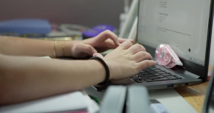 Typing on Laptop: Close-up of hands typing on a laptop keyboard, focusing on the action and the digital workspace.