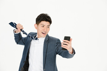 Naklejka premium Excited businessman checking smartphone and pulling tie on white background