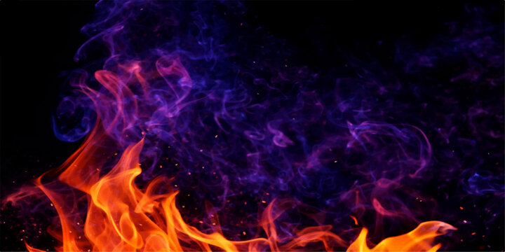An abstract background of burning fire flames and smoke exploding in the dark with hot orange and red inferno energy