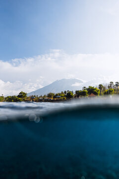 Ocean and volcano mountain in Bali. Split view of blue ocean waters surface
