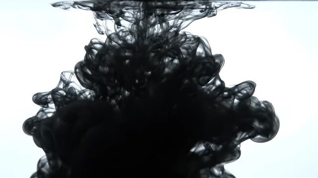 Black Ink Cloud Dissolving in Clear Water Abstract Motion - A dramatic cloud of black ink slowly dissolves and dissipates into clear water, creating ethereal shapes and patterns.