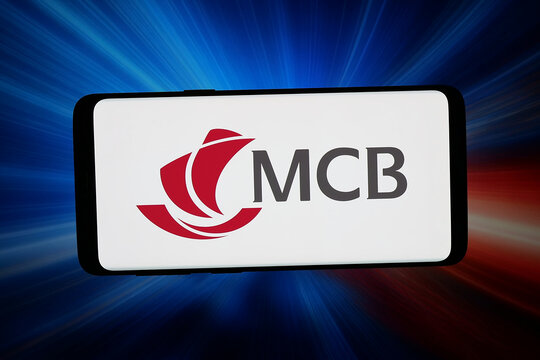 Stuttgart, Germany - 05-20-2026: In this photo illustration, the logo of company Mauritius Commercial Bank (MCB) is displayed on a smartphone in front of abstract background on computer screen.