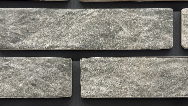 Dark grey stone brick wall texture background with rustic slate marble tiles