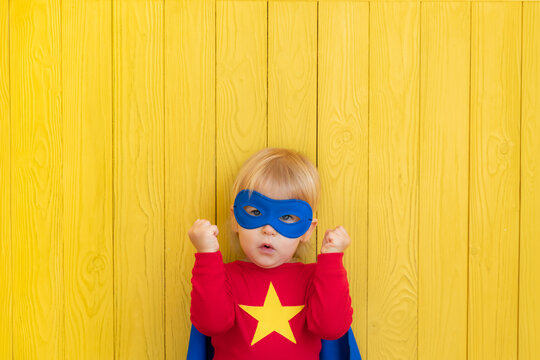 Little boy dressed as a superhero having fun at home