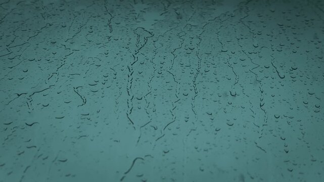 Gotas de lluvia desliz&aacute;ndose sobre una ventana creando una textura abstracta azul &mdash; v&iacute;deo 4K