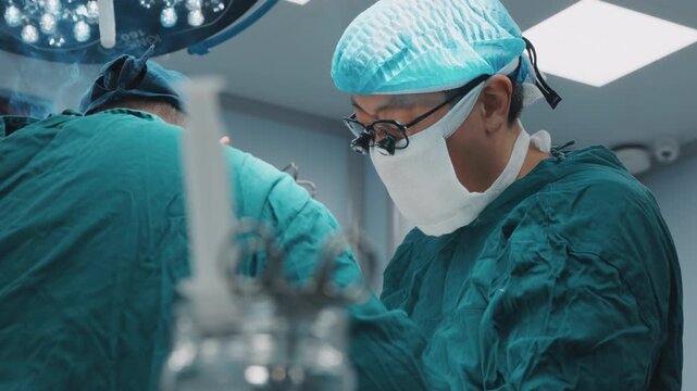 Close-up surgeons during operation with medical instruments under sterile conditions. Professional healthcare teamwork transplantation plastic surgery