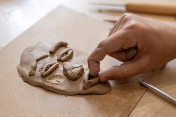 Child creating clay face sculpture during art therapy, emotional expression and identity formation concept © Светлана Мищенко