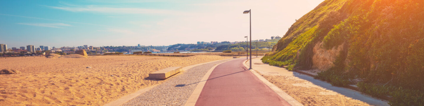 Promenade along the sea and Atlantic ocean in spring. Beautiful bay on a sunny day. View of Porto city on the horizon. Douro Cabedelo Beach, Portugal, Europe