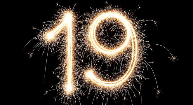 Vibrant sparklers forming the number 19 in a celebratory fireworks display against a dark background.