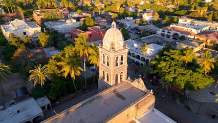 Sunset casts colors over aerial of Loreto Mission church in Baja California Sur Mexico. The oasis stands amidst the desert landscape and city © Robert Peak