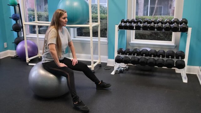 Woman exercising on stability ball in gym