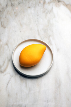 Mango mousse dessert on a ceramic plate