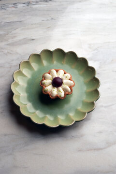 Flower shaped lemon tart dessert on a ceramic plate