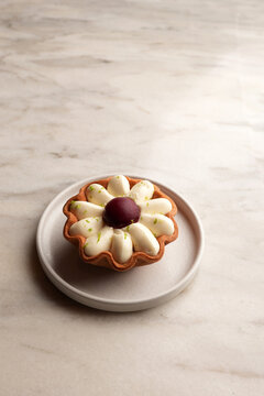 Flower shaped lemon tart dessert on a ceramic plate