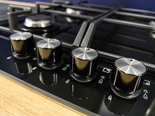 Obraz premium Kitchen appliance gas stove showing control panel and knobs, retail supermarket display, metal surface with functional adjustment for home cooking