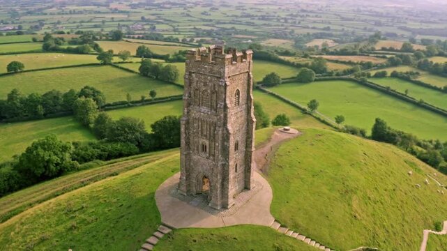 Dramatic aerial orbit of Glastonbury Tor, the ancient St Michael's Tower in Somerset, England