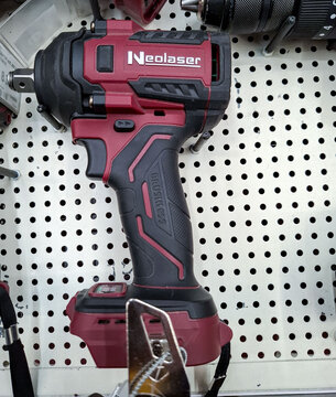 Voronezh, Russia - April 8, 2026.Maroon and black Neolaser brushless cordless impact wrench displayed on a white rack in a hardware store in Russia