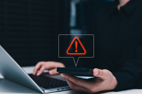 Cybersecurity warning alert and cyber risk notification concept. Person using smart phone and laptop, red danger icon, account threat, fraud detection, data protection, system error, verification