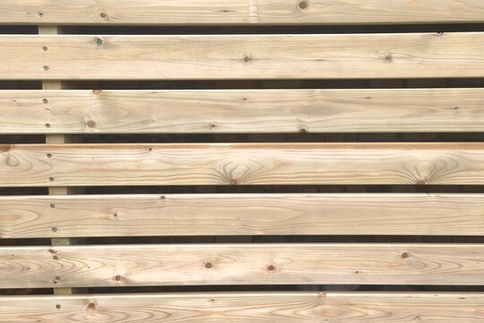 Horizontal timber slats panel texture showcasing natural wood grain and parallel lines. Scenic wooden planks siding close up layout for a lumber supplier warehouse