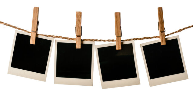 Four blank instant photo prints attached with wooden clothespins to a rope, isolated on transparent background