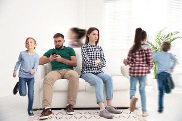 Fototapeta premium Family with hyperactive children. Daughter and son running around tired parents at home