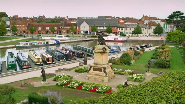 Descending aerial shot of the Gower Memorial revealing Bancroft Gardens and the River Avon canal basin