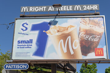 Obraz premium close-up of roadside billboard for McDonald's Canada restaurant chain on St Clair Av W (with direction to location at Keele St), Toronto