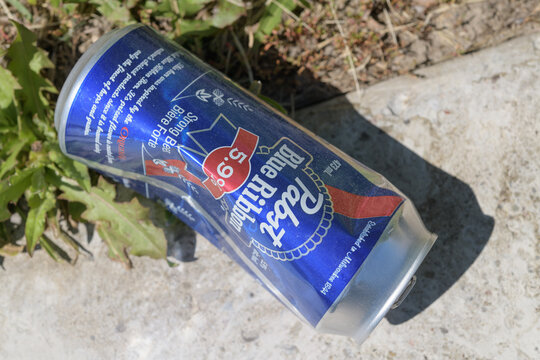 slightly crushed, discarded aluminum can of Pabst Blue Ribbon 5.9% alc strong beer outdoors, Toronto